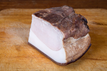 Ukrainian smoked lard on the old board. Shallow depth of field