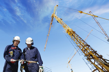 construction workers and giant mobile cranes
