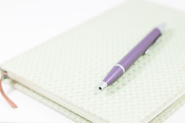 Closeup notebook with pen on white background
