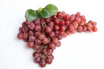 Red grapes with fresh leaves, isolated on white background