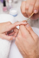 Manicurist cleaning a customers nails