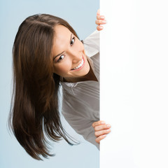 Businesswoman showing signboard, over blue