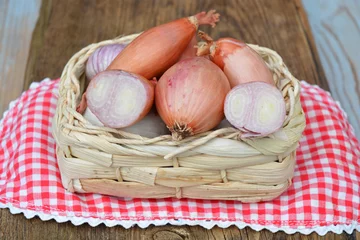 Rollo Schalotten, Knoblauch und Zwiebeln in einem Korb mit einem Tuch © trinetuzun