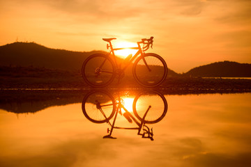 Bicycle parked near a lake with reflection