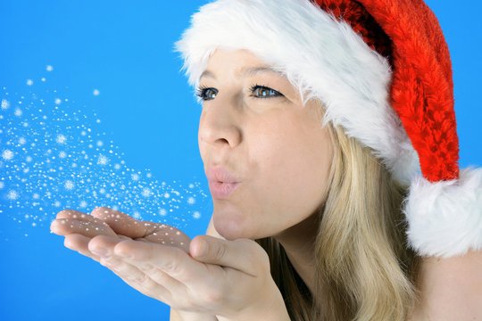 Frau zu Weihnachten pustet Schnee