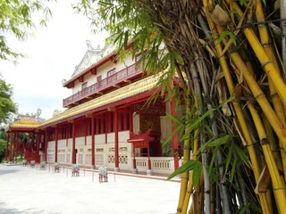 Cercles muraux Temple A traditional Chinese temple or palace seen past a clump of golden bamboo stalks