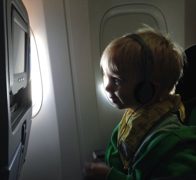 Kind schaut fernsehen im Flugzeug