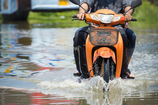 Splash by a motorcycle as it goes through flood water