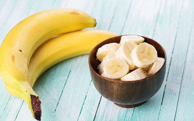 Sliced banana in bowl on  wooden background. Selective focus.