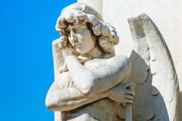 Obraz premium Beautiful young male angel on a blue sky with space for text