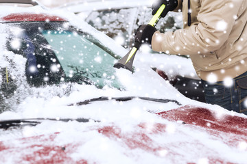 closeup of man cleaning snow from car