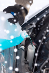 closeup of man pouring antifreeze into car