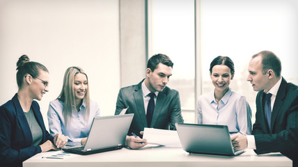 business team with laptop having discussion