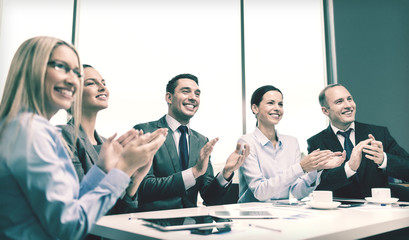 business team with laptop clapping hands