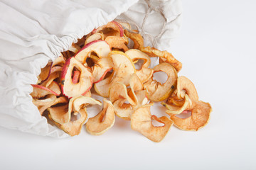 Poured out of the bag of dried apples on a white background.