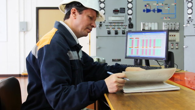 engineer looks working log while sitting at table, close-up