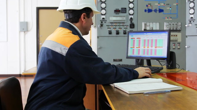 engineer works on computer sitting at desk, close-up