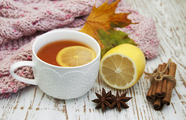 Cup of hot tea with lemon and scarf
