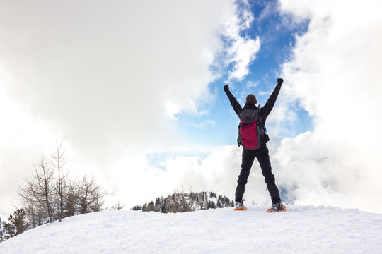Uomo con braccia in alto in montagna d'inverno