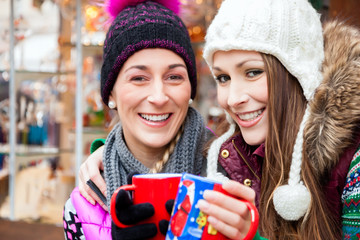 Freunde trinken Glühwein auf Weihnachtsmarkt