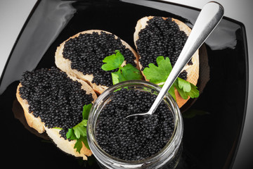Sandwiches with black caviar on dark plate