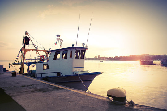 Fototapeta Industrial fishing boat is moored in port. Vintage toned photo