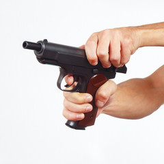 Hands reload pistol on a white background