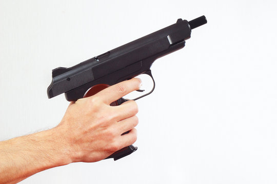 Hand with discharged pistol on a white background