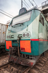 Modern green cargo train locomotive with red signs