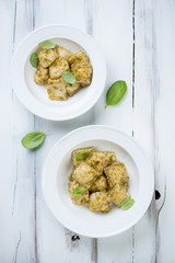 Above view of ravioli with basil pesto, rustic wooden surface