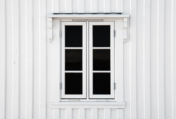 Window in white wooden wall. Norway architecture