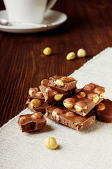 Slices of milk chocolate with nuts closeup on a cotton napkin