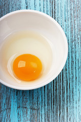 Crude egg yolk in a white ceramic cup