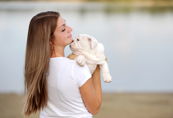 the young woman holds on hands of a puppy of breed the boxer and