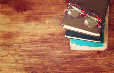 Top view of old books on a wooden table. retro filtered image
