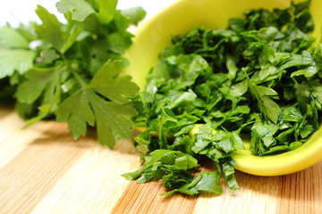 Fresh, natural and chopped parsley on wooden cutting board