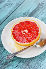 Grapefruit with honey on a white plate