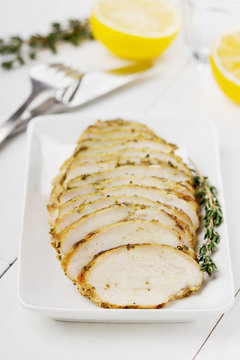 Chicken fillet slices with thyme on a white plate