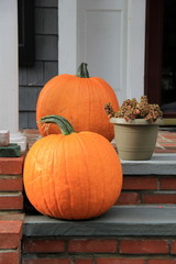 Two large pumpkins on stone and brick steps