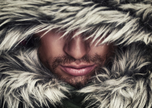 brutal face of man with beard bristles and hooded winter