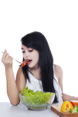 Pretty woman eats a bowl of salad