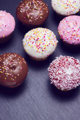 Top view showing cupcakes on black slate, space for text