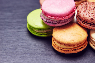 Macaroons in different colours on black slate