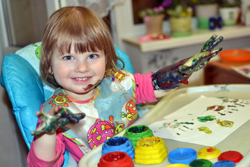 beautiful girl draws with finger paints