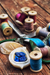 buttons in the box-of-pearl on the background of yarn spools