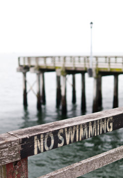 No Swimming Sign On Pier Fence. Coney Island.