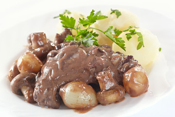 Chicken in red wine with onions, mushrooms and bacon