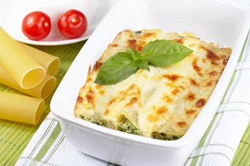 Gordijnen Cannelloni with spinach and ricotta baked in sauce bechamel © Galina Mikhalishina