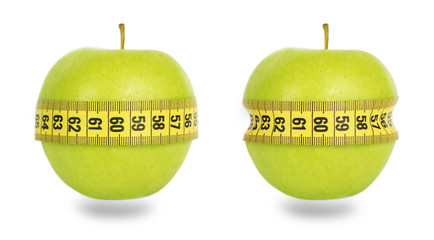 Two green apples and yellow measuring tape