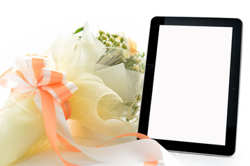 Tablet computer and bouquet of flowers isolated on white